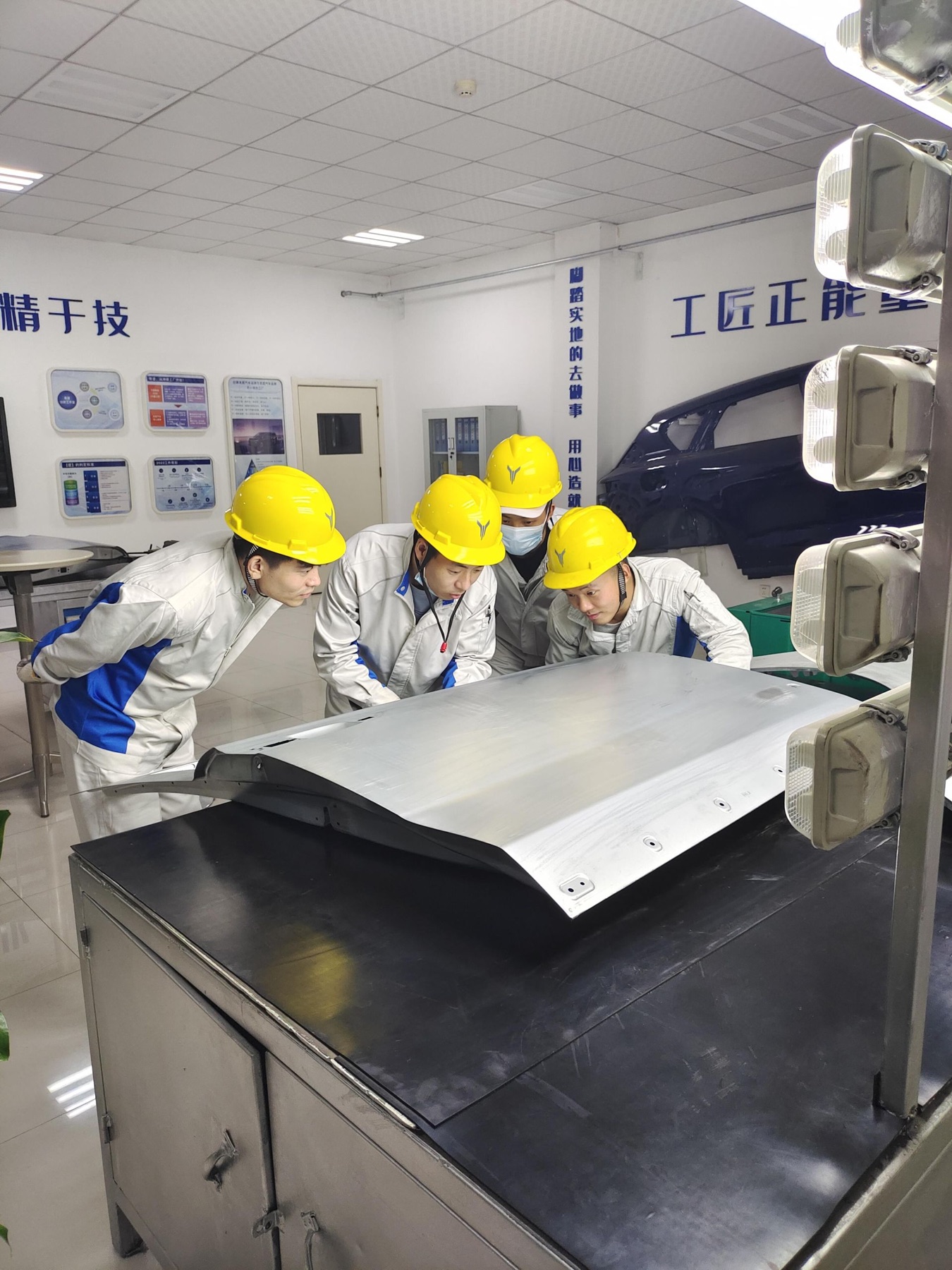 Mockup engineers inspecting a formed sheet metal panel